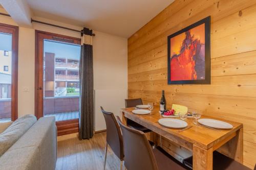 l'Ours Bleu C21 - Ski In Ski Out - Happy Rentals في فالورسين: غرفة طعام مع طاولة وأريكة