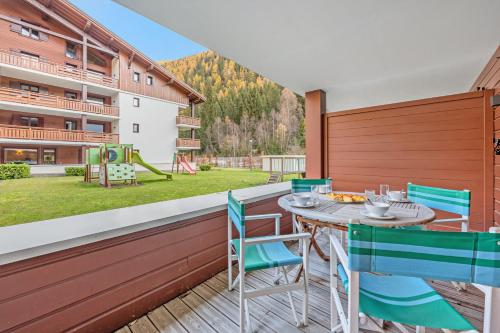 l'Ours Bleu C21 - Ski In Ski Out - Happy Rentals في فالورسين: فناء مع طاولة وكراسي وملعب