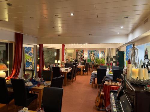 ein Restaurant mit Tischen und Stühlen und einem Klavier in der Unterkunft Hotel Haus Niggemann in Hattingen
