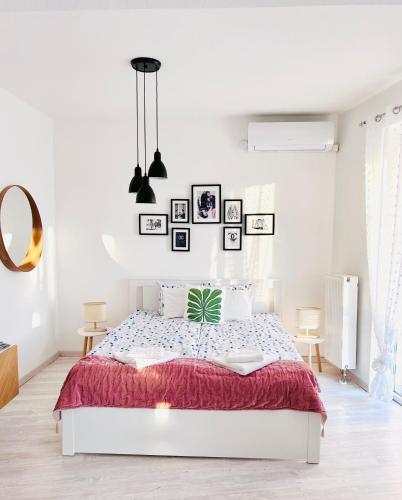 Belvárosi Stúdió Apartman في كيسكيميت: غرفة نوم بيضاء مع سرير وبطانية حمراء