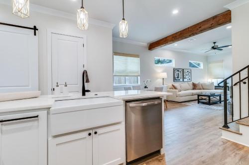 a kitchen with white cabinets and a living room at Brand New Designer Townhome in the Middle of Town in Lafayette