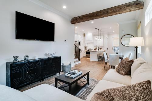 a living room with a couch and a tv on a wall at Brand New Designer Townhome in the Middle of Town in Lafayette