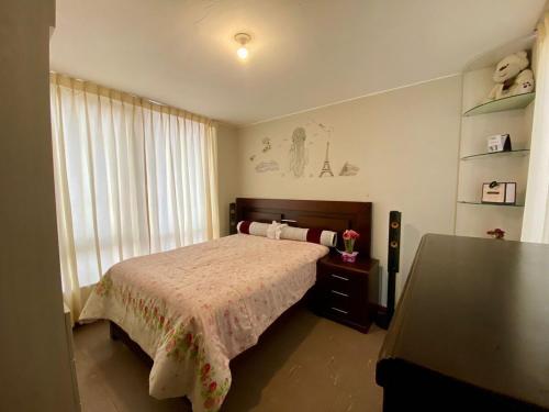 ein Schlafzimmer mit einem Bett und einem großen Fenster in der Unterkunft como en tu casa mollendo in Mollendo