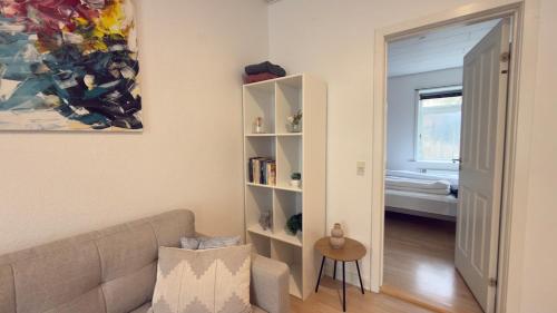a living room with a couch and a book shelf at Apartment in the heart of Esbjerg Center in Esbjerg