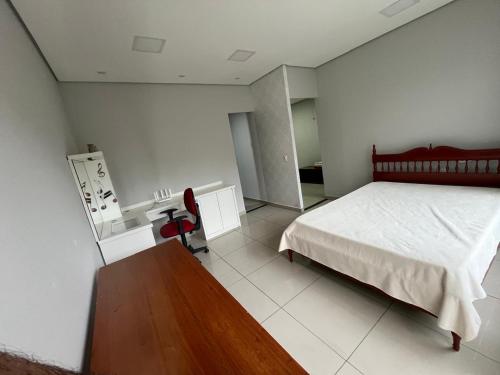 een slaapkamer met een bed en een houten tafel bij Casa da Vivi in Socorro