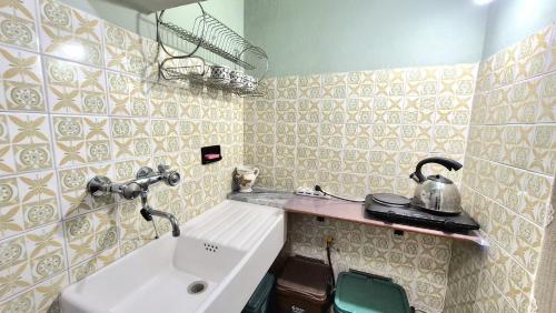 a bathroom with a sink and a tea kettle on a shelf at Villa Due Cieli 4 in Lanzo dʼIntelvi