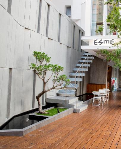 a building with a staircase and a tree in a courtyard at Hotel Mapp in Taichung