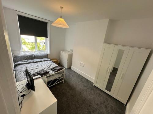 a bedroom with a bed and a desk with a computer at Apartment Masons Hill in Bromley