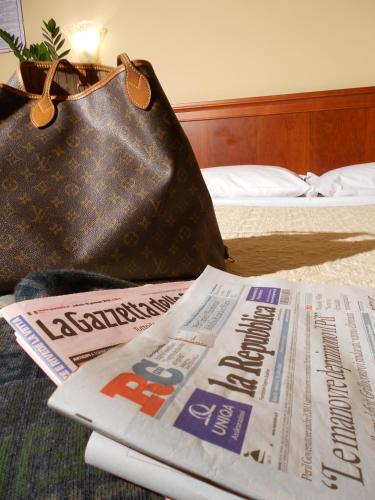 a newspaper and a purse sitting on a bed with a newspaper at Magic Hotel in Atena Lucana