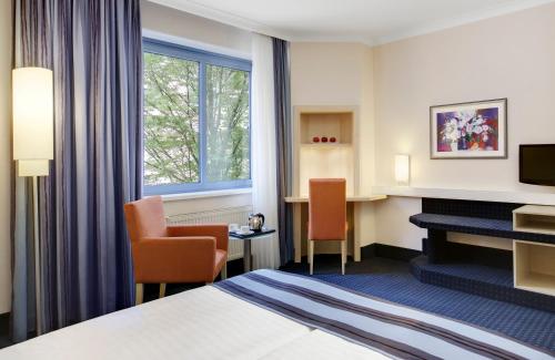 a hotel room with a bed and a desk at Hotel Nürnberg City Center by Leonardo Hotels in Nürnberg
