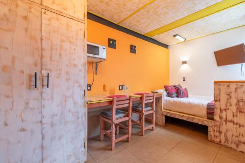 a room with a bed and a table and chairs at Lofts San Ángel in Mexico City