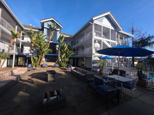 un bâtiment avec un patio avec des chaises et un parasol dans l'établissement Hotel Solares, à Santa Cruz