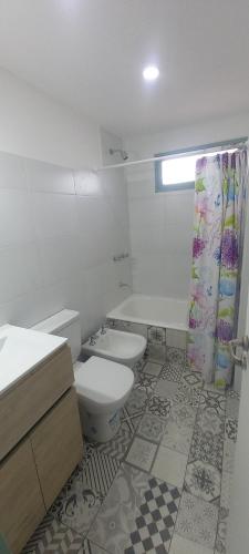 a bathroom with a toilet and a sink and a shower at Trelew Cartref-Departamento Familiar Cerca del centro in Trelew