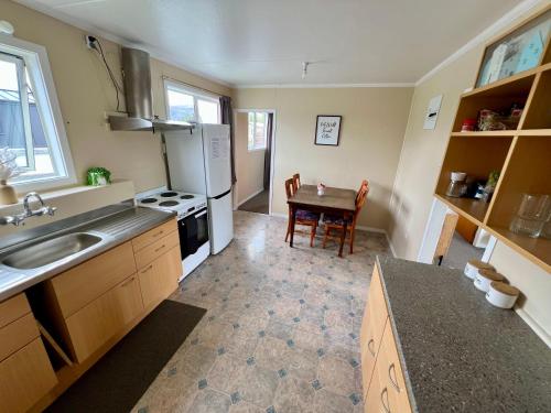 a kitchen with a sink and a table in it at Mackenzie Cottage in Twizel