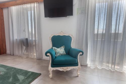 a blue chair with a pillow in a living room at Casa dos Romeiros in Santa Bárbara