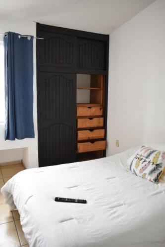 Casa Familiar, Independiente y amplia في Hércules: غرفة نوم بسرير ابيض وخزانة