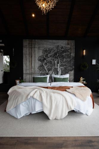 a bedroom with a large bed with a wall at Noma Cabin in Măguri
