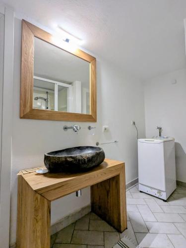 a bathroom with a large rock sink and a mirror at Casa colore intera casa nel borgo antico in Ossuccio