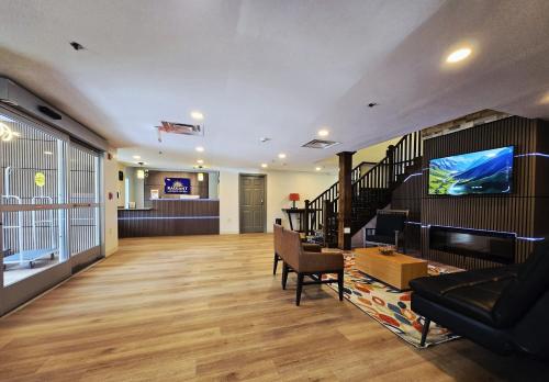 a lobby with a living room with a tv and stairs at Radiant Inn and Suites in Murfreesboro