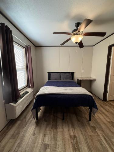 a bedroom with a bed and a ceiling fan at Mesquite Oasis Lodging in Odessa