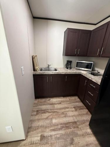 a small kitchen with a sink and a microwave at Mesquite Oasis Lodging in Odessa
