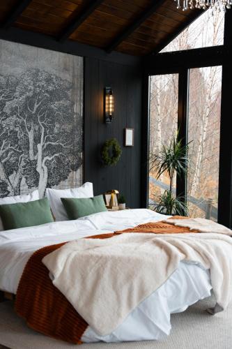 Un dormitorio con una cama grande con una ventana grande. en Noma Cabin, en Măguri