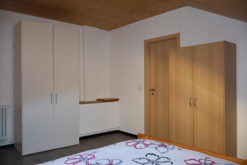 a bedroom with a bed and a wooden cabinet at Casa Anna in Osogna