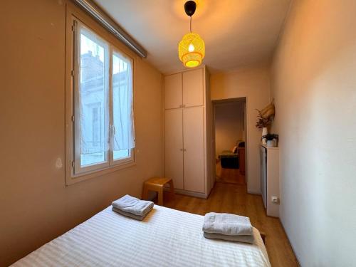 Un dormitorio con una cama con dos toallas encima. en Le Repaire des Sablons 2 Pers 150m place du marche, en Fontainebleau