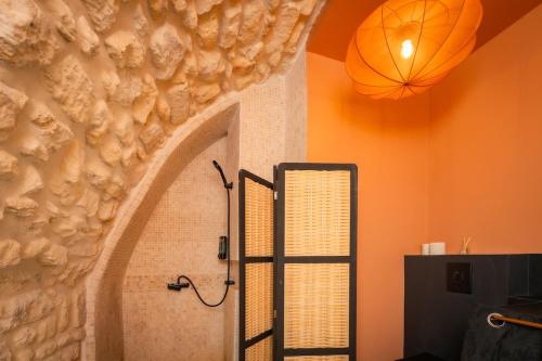 a shower in a bathroom with an orange wall at Exceptional Apartment Île Saint Louis - Jacuzzi in Paris