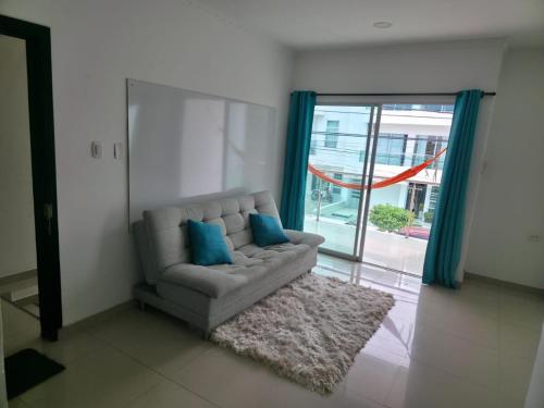 ein Wohnzimmer mit einem Sofa mit zwei blauen Kissen in der Unterkunft Apartamento de lujo en el norte de Monteria in Montería