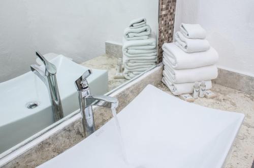 a bathroom with a sink and a mirror and towels at BSEA Cancun Plaza Hotel in Cancún