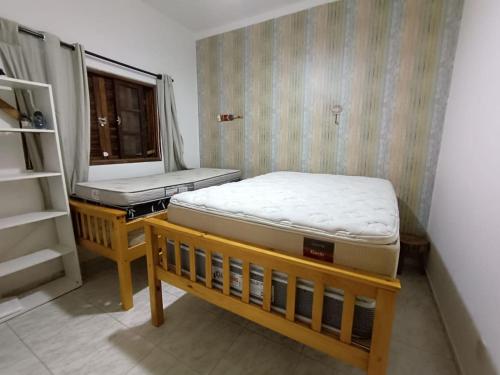 House with Atlantic Forest in the background - Saíra Sete Cores في بيرتيوغا: غرفة بها مرتبتان ونافذة