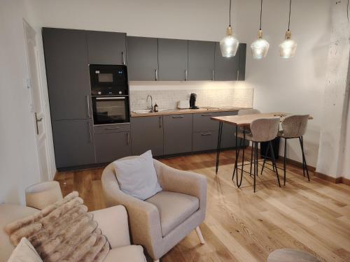 a kitchen and living room with a table and chairs at Majestueux Bouquet in Le Mans