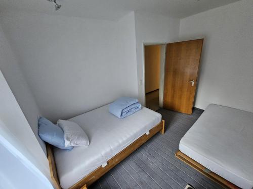 クールにあるPrivate 3-Zimmer Apartment -Private WC, Dusche, Küche-のベッドと木製のドアが備わる小さな客室です。