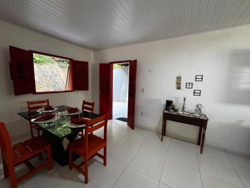 a dining room with a table and chairs and a window at Casa Alegria - Praia de Catuama -PE in Goiana