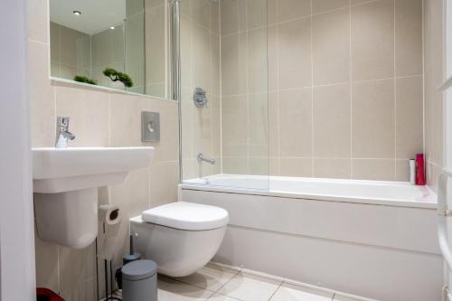 Un baño con inodoro, lavabo y bañera. en Leeds - City Stay on the River - Sleeps 10 - Central, en Central Station