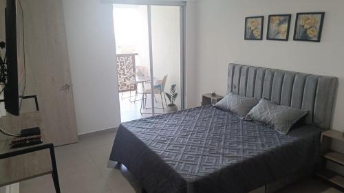 Un dormitorio con una cama con un edredón azul. en Mandala - Confort y lujo cerca del parque deportivo, en Ibagué