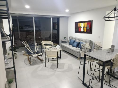 Una sala de estar con un sofá, una mesa y sillas. en Mandala - Confort y lujo cerca del parque deportivo, en Ibagué
