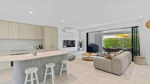 a kitchen and living room with a couch and a table at Pacific Chill 2 Mins Walk to Beach in Hawks Nest