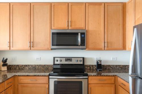 a kitchen with a stove and a microwave at Kasa South Loop Chicago in Chicago