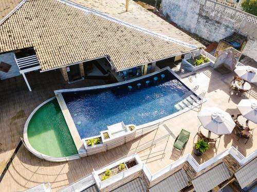 an overhead view of a swimming pool with tables and umbrellas at Flat Luxo 213 - Pipas Bay in Pipa
