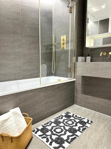 a bathroom with a shower and a black and white rug at Kings cross Exclusive Residence 3BR in London