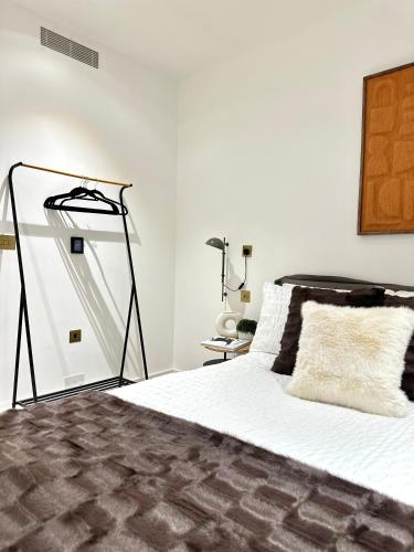 a bedroom with a bed with white sheets and a lamp at Kings cross Exclusive Residence 3BR in London