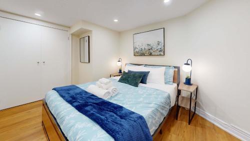 a bedroom with a large bed with a blue blanket at Cozy Basement Apartment for 4 - Near Cafes & Parks in Toronto