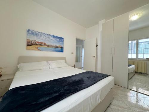 ein weißes Schlafzimmer mit einem großen Bett und einem Badezimmer in der Unterkunft Amami - Gallipoli in Gallipoli