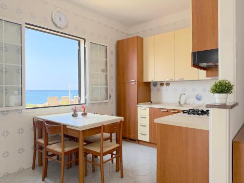 eine Küche mit Tisch und Blick auf das Meer in der Unterkunft Amami - Gallipoli in Gallipoli