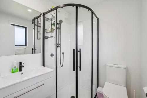 ein Badezimmer mit Dusche, Toilette und Waschbecken in der Unterkunft Cosy 4 Bedroom Home in Queenstown Airport