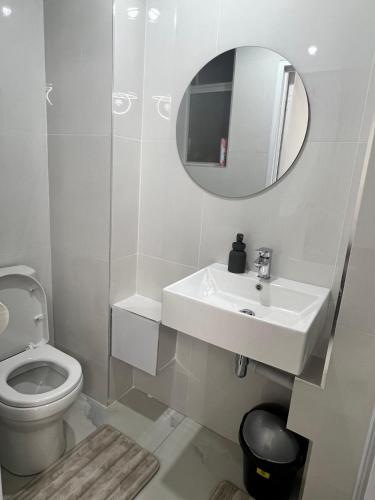 a white bathroom with a sink and a mirror at The Oceanic 42 in Durban