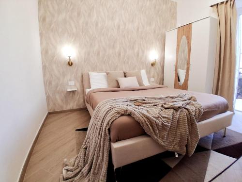 een slaapkamer met een bed met een deken erop bij Mastedè in Tivoli