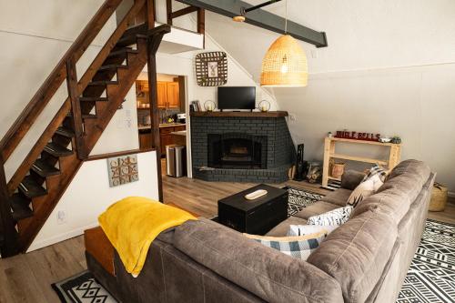 Una sala de estar con un sofá y una chimenea. en Rustic Retreat, en Blakeslee